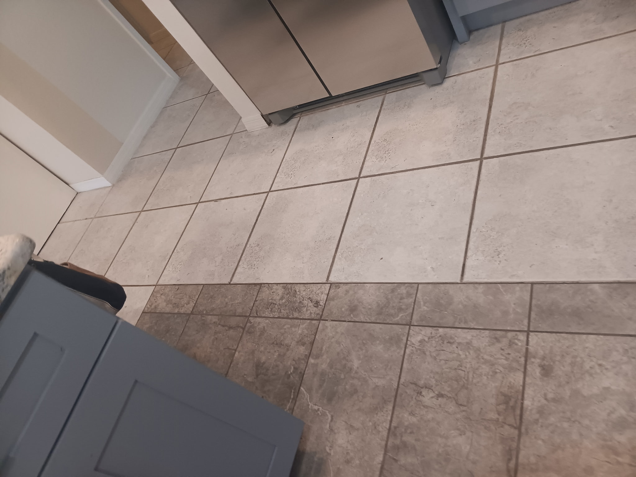 Tile floor half cleaned by DirtyGrout showing dirty versus restored grout lines