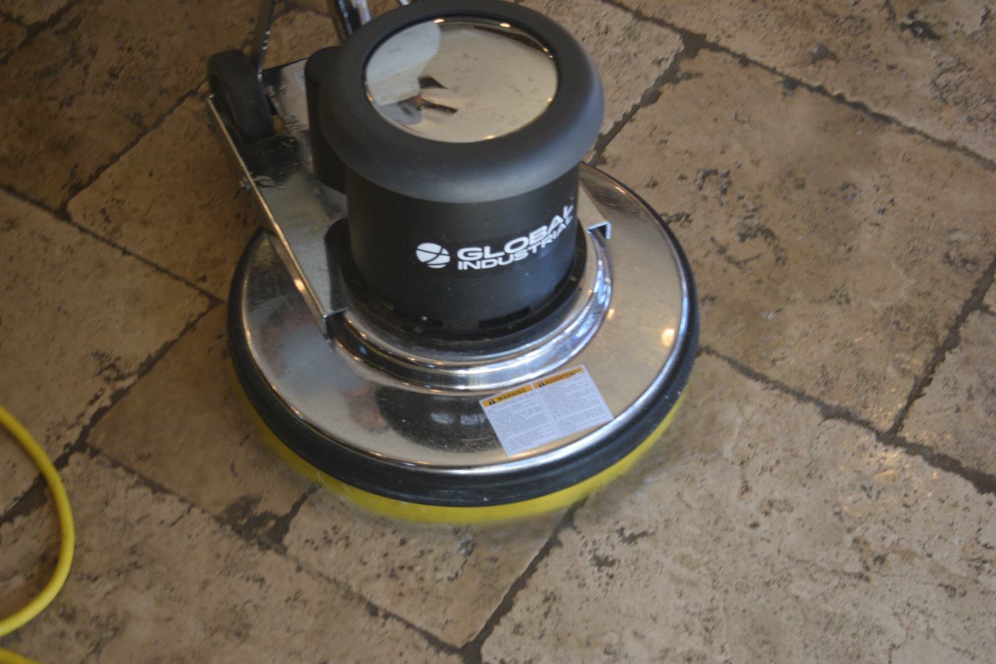 Professional rotary floor machine on a natural stone tile floor